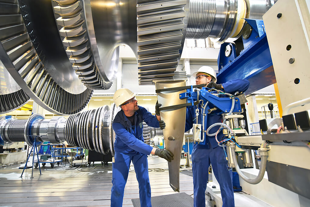 Zielmarkt Maschinenbau – Arbeiter in Blaumann mit Helm